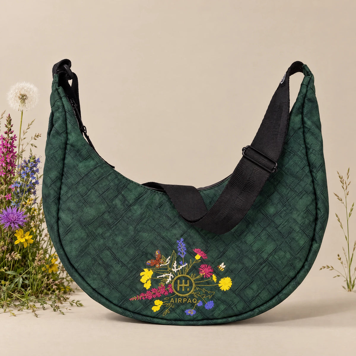 Moonbaq Mini Robinga-Edition Auflage 2 – Frontansicht mit Blumenstickerei auf sandfarbenem Hintergrund